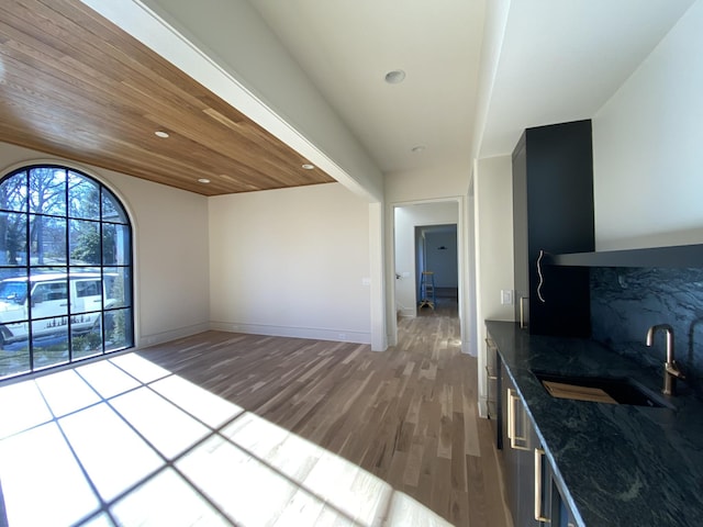 kitchen with light wood-type flooring, sink, and wooden ceiling