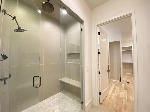 bathroom with hardwood / wood-style floors and a shower with door