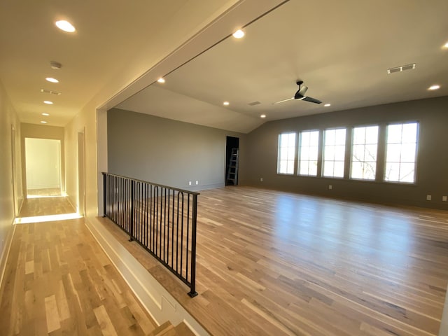 spare room with lofted ceiling, ceiling fan, and light hardwood / wood-style flooring