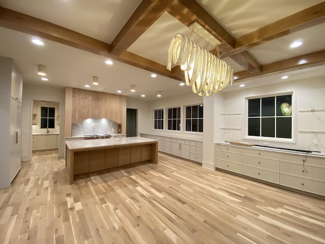 kitchen with a large island, pendant lighting, light hardwood / wood-style floors, and a chandelier