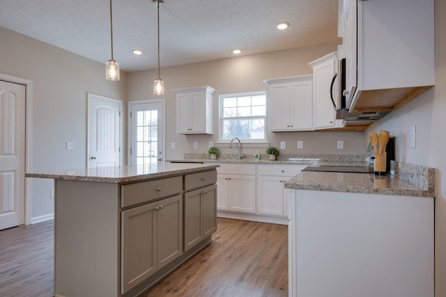 kitchen featuring white cabinetry, light hardwood / wood-style floors, a center island, and range