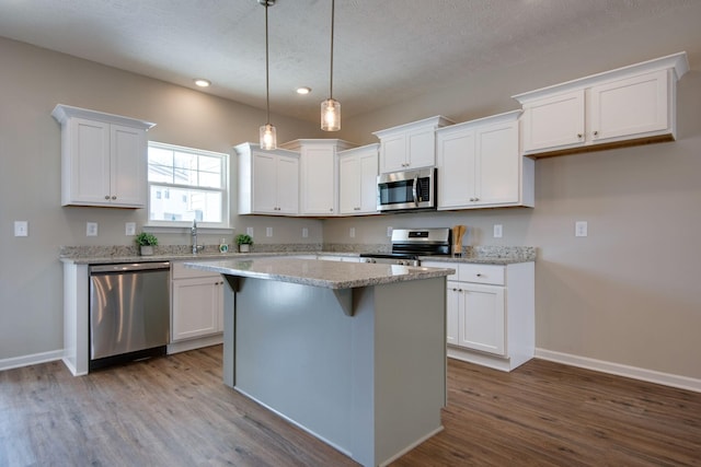 kitchen with white cabinetry, appliances with stainless steel finishes, and a center island