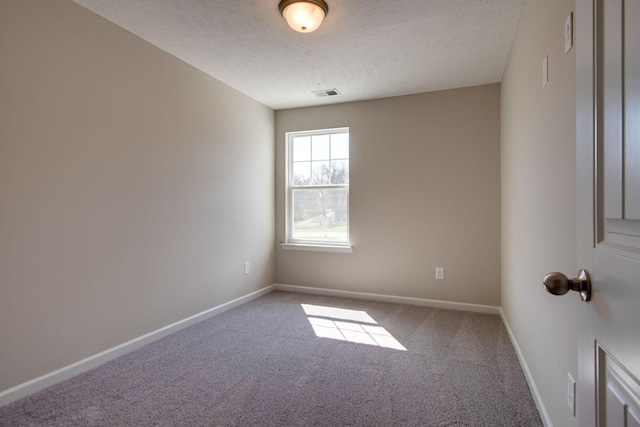 unfurnished room featuring carpet and a textured ceiling