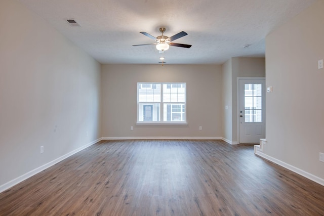 unfurnished room with ceiling fan, a healthy amount of sunlight, wood-type flooring, and a textured ceiling