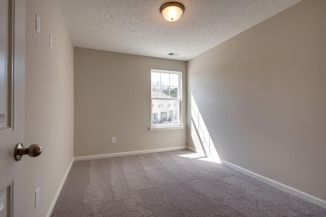 unfurnished room featuring carpet floors and a textured ceiling