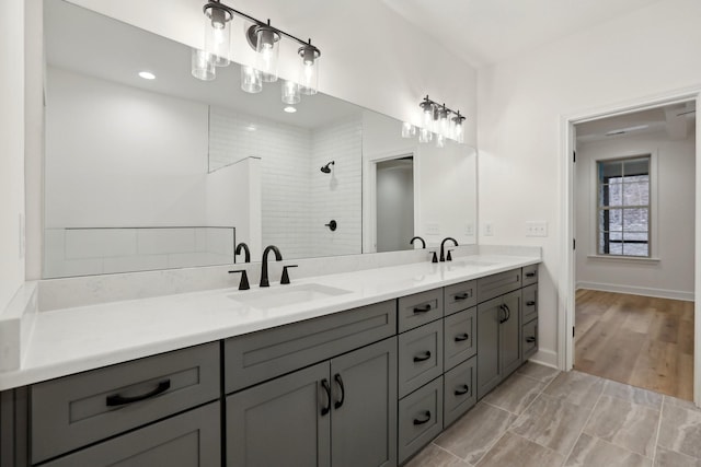 bathroom featuring a tile shower, vanity, and hardwood / wood-style flooring