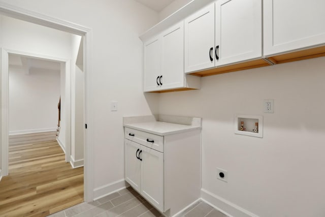 clothes washing area featuring light tile patterned floors, hookup for a washing machine, cabinets, and hookup for an electric dryer