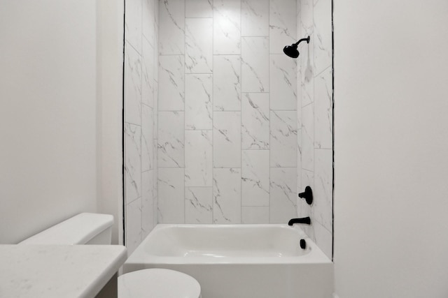 full bathroom featuring tiled shower / bath combo, vanity, and toilet