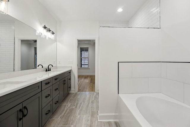 bathroom featuring vanity and a washtub