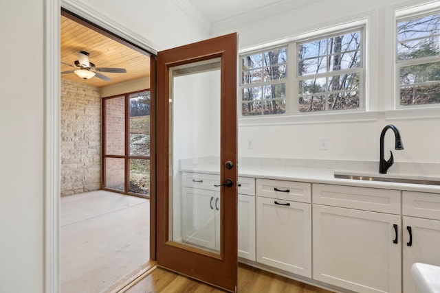 interior space featuring sink, crown molding, light hardwood / wood-style flooring, and ceiling fan