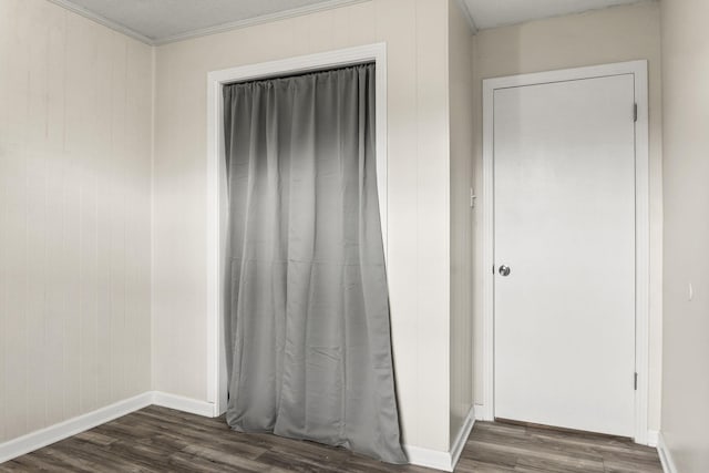 interior space with ornamental molding and dark wood-type flooring