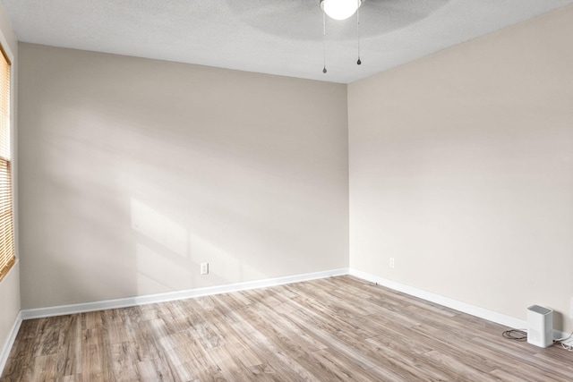 unfurnished room featuring ceiling fan, a textured ceiling, and light wood-type flooring