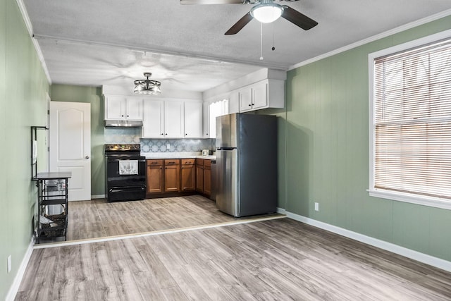 kitchen featuring white cabinetry, black range with electric stovetop, plenty of natural light, and stainless steel fridge