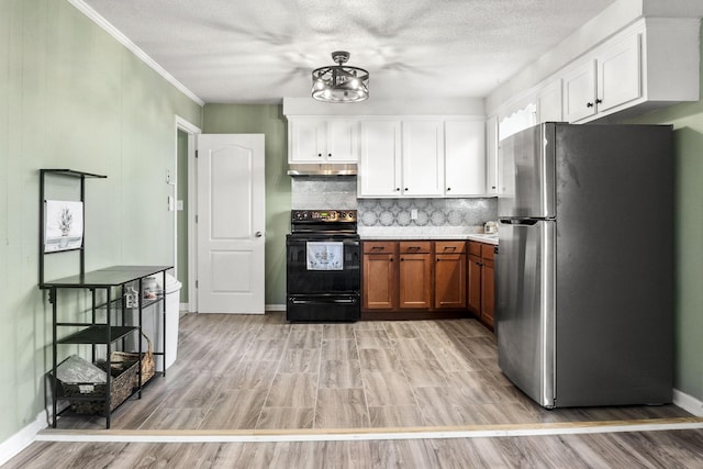 kitchen with stainless steel refrigerator, white cabinets, decorative backsplash, electric range, and crown molding