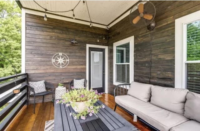 wooden deck with ceiling fan and an outdoor living space