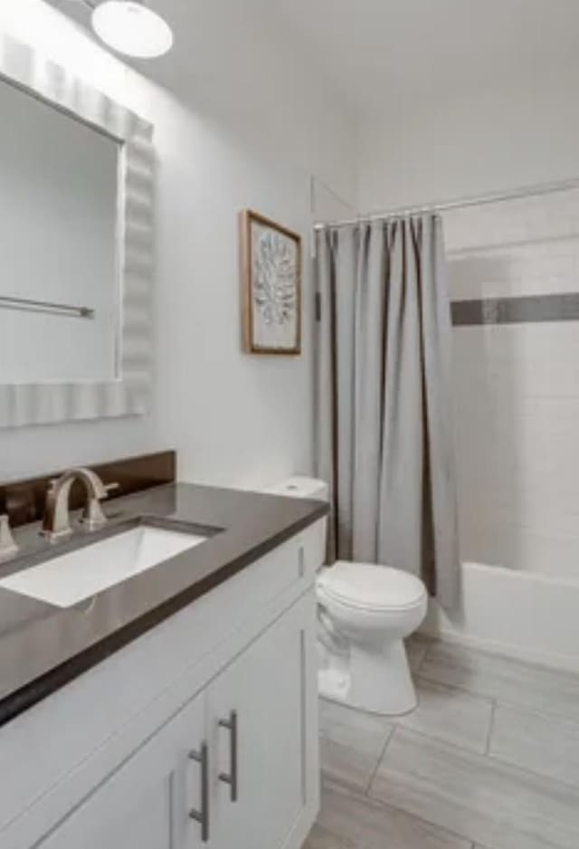 bathroom featuring shower / tub combo, vanity, and toilet