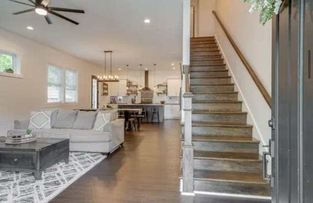 living area with ceiling fan, stairway, wood finished floors, and recessed lighting