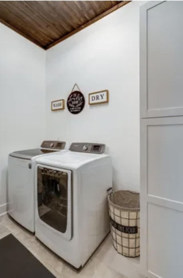 clothes washing area with wooden ceiling and separate washer and dryer