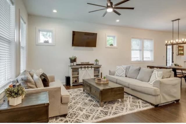 living area with ceiling fan with notable chandelier, wood finished floors, and recessed lighting