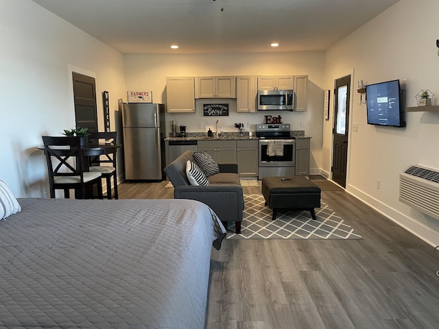 bedroom featuring freestanding refrigerator, dark wood finished floors, a sink, and recessed lighting