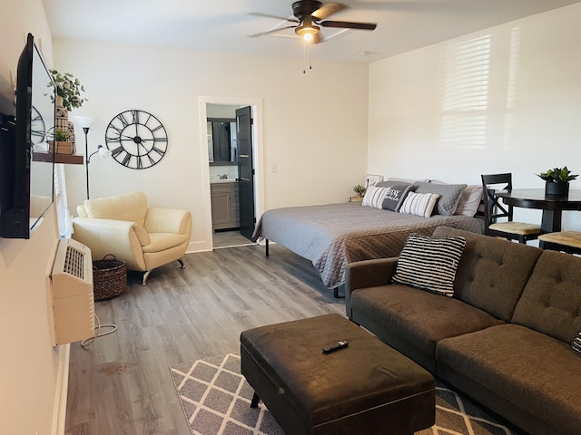 bedroom with a sink, light wood-style flooring, and connected bathroom