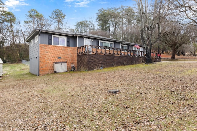 view of front of property with a wooden deck and a front yard