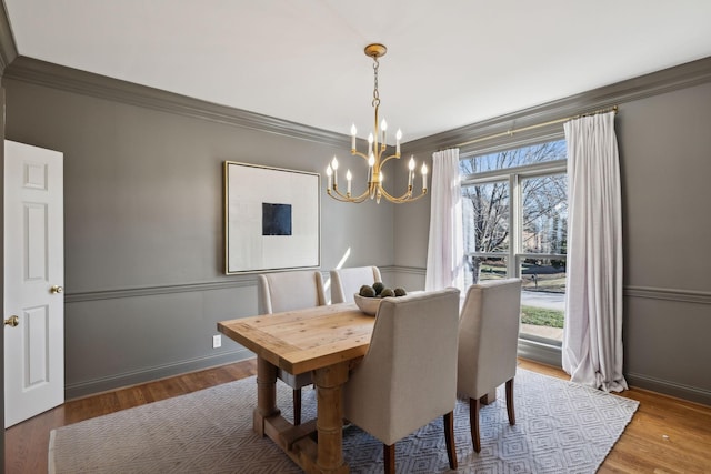 dining room with an inviting chandelier, ornamental molding, hardwood / wood-style flooring, and plenty of natural light