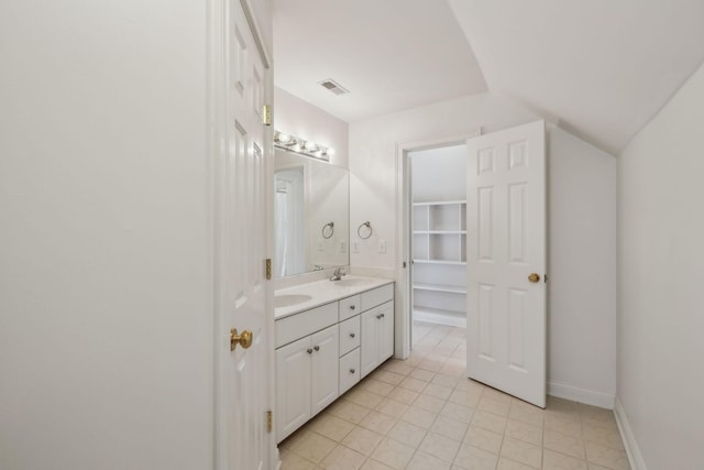 bathroom featuring vanity, tile patterned flooring, and vaulted ceiling