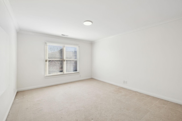 spare room featuring ornamental molding and light colored carpet