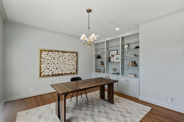 home office featuring an inviting chandelier, crown molding, built in features, and light wood-type flooring