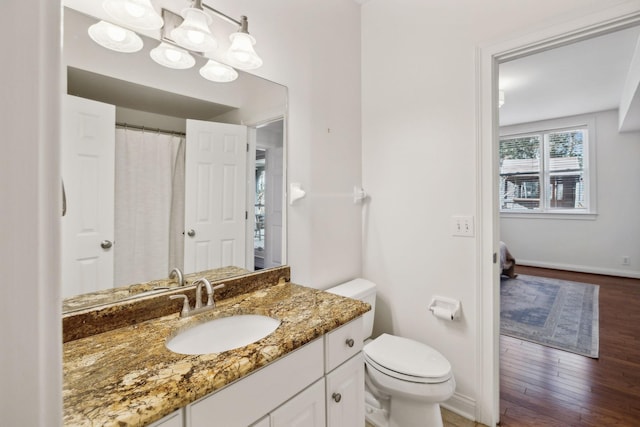 bathroom with vanity, toilet, and hardwood / wood-style floors