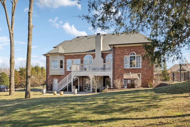 back of property featuring a wooden deck and a lawn