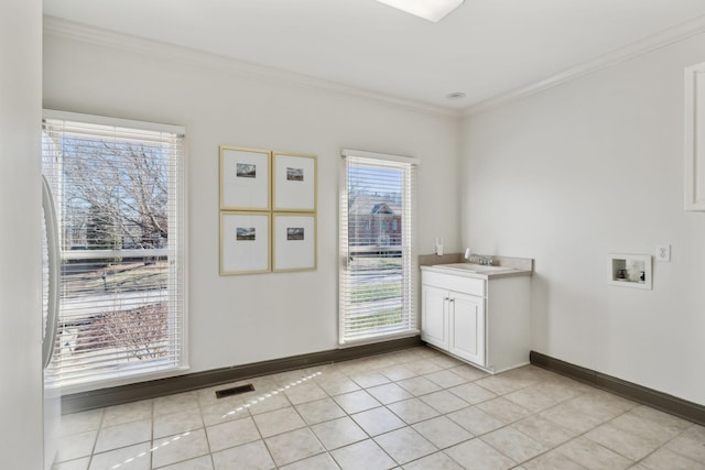 interior space featuring light tile patterned flooring, cabinets, washer hookup, and a wealth of natural light