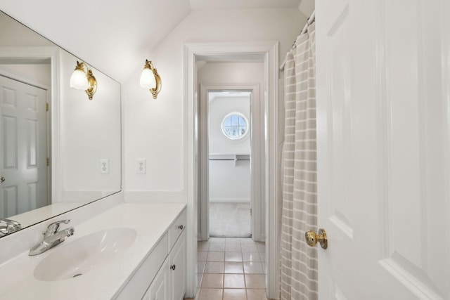 bathroom featuring vanity, tile patterned flooring, and vaulted ceiling