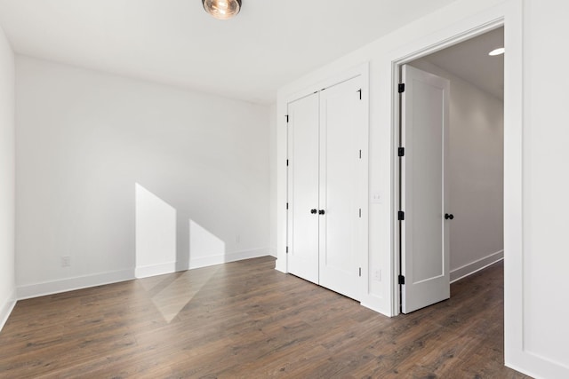 unfurnished bedroom featuring dark hardwood / wood-style flooring and a closet