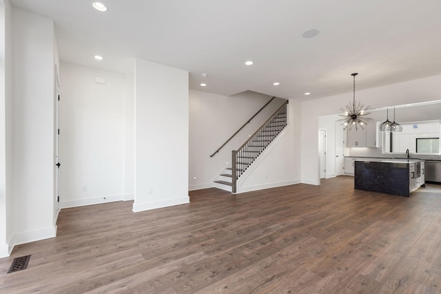 unfurnished living room with hardwood / wood-style flooring and an inviting chandelier