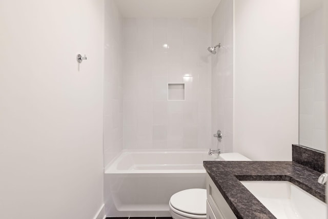 full bathroom featuring tiled shower / bath, vanity, tile patterned floors, and toilet