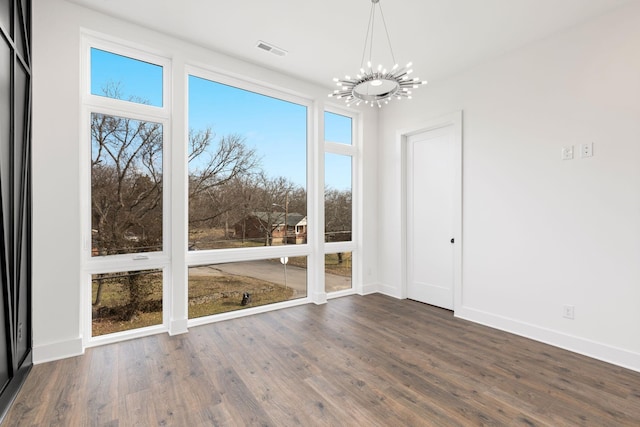 unfurnished dining area featuring dark hardwood / wood-style flooring and a chandelier