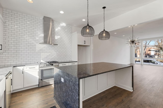 kitchen with white cabinetry, stainless steel appliances, dark stone counters, and wall chimney exhaust hood