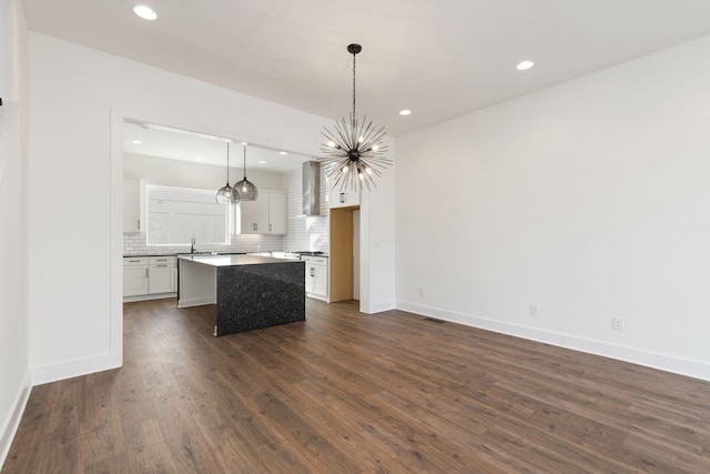 kitchen featuring sink, hanging light fixtures, a kitchen island, and white cabinets