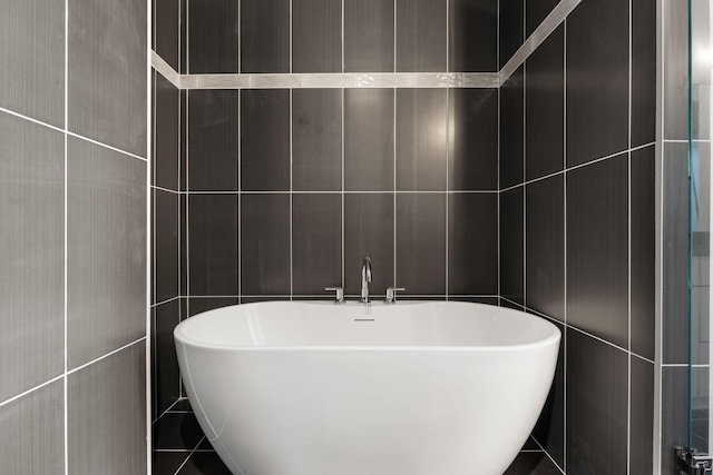 bathroom with tile walls and a bathing tub