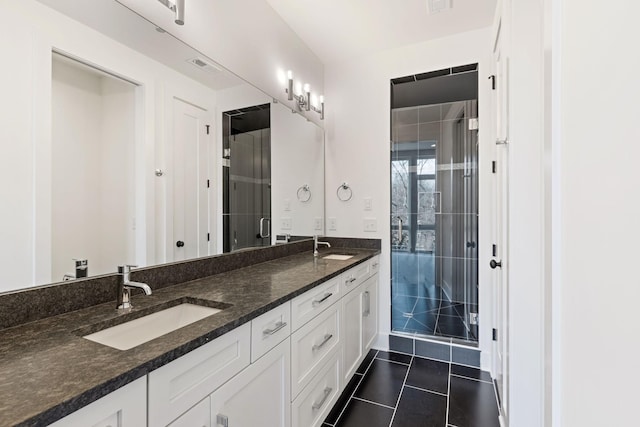 bathroom featuring tile patterned flooring, vanity, and walk in shower