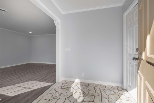 unfurnished room featuring visible vents, baseboards, and ornamental molding