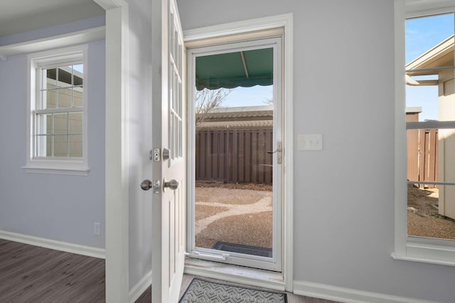 doorway to outside with plenty of natural light, baseboards, and wood finished floors