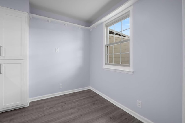 empty room with baseboards and dark wood-style flooring