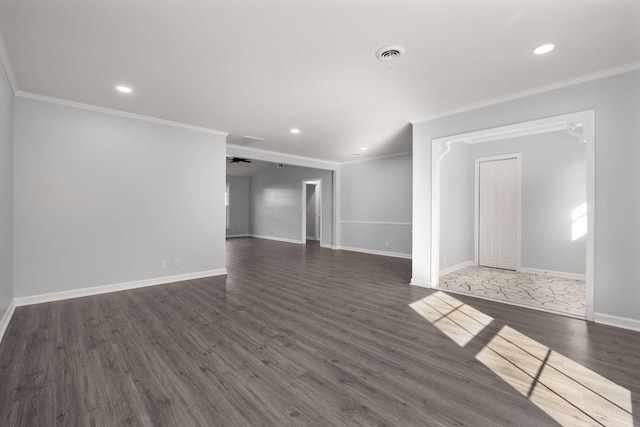 empty room featuring visible vents, baseboards, recessed lighting, dark wood-type flooring, and crown molding