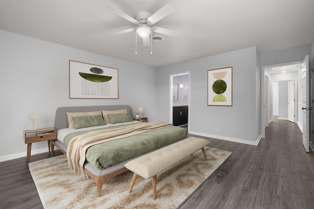 bedroom featuring dark wood finished floors, ensuite bath, and baseboards