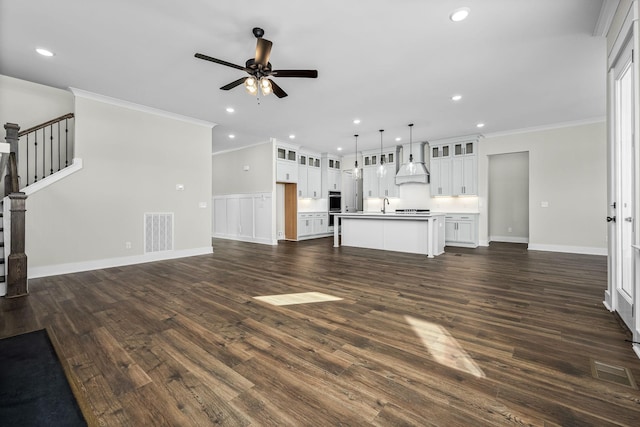 unfurnished living room with ornamental molding, sink, ceiling fan, and dark hardwood / wood-style flooring