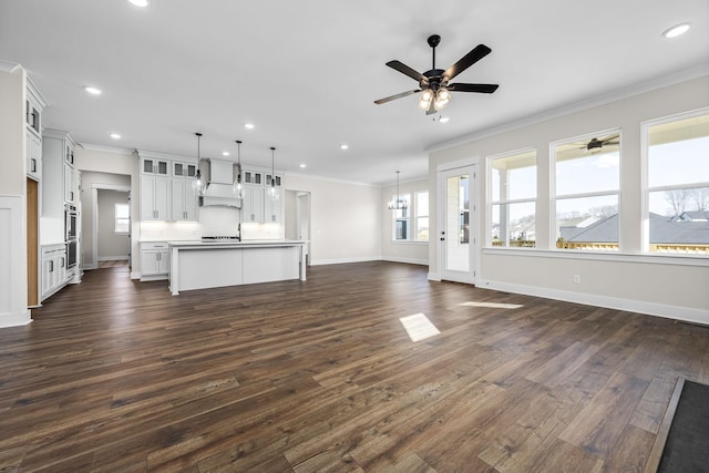 unfurnished living room featuring crown molding, dark hardwood / wood-style floors, and ceiling fan