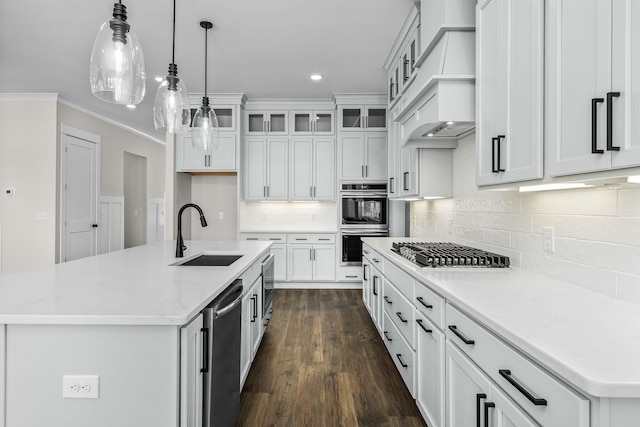 kitchen featuring stainless steel appliances, a kitchen island with sink, sink, and white cabinets